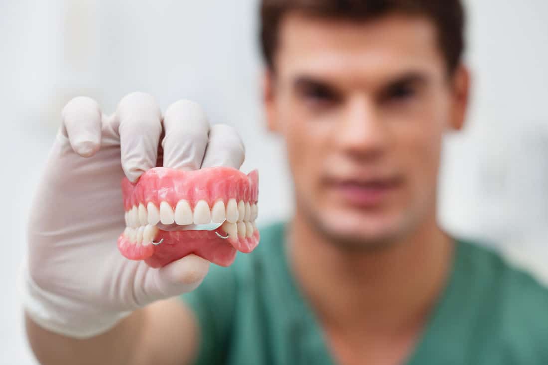 dentist holding dentures partials